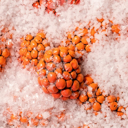 This close-up image showcases vibrant orange cloudberries surrounded by delicate ice crystals, emphasizing their freshness and natural richness. Cloudberries are known for their antioxidant properties and high vitamin content, making them a luxurious ingredient in skincare formulations. The combination of the berries and ice conveys purity, vitality, and the power of nature, perfect for representing nourishing and restorative benefits.